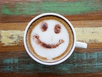 coffee with a happy face drawn in the milk